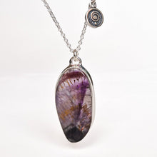 Load image into Gallery viewer, A silver chain necklace with a teardrop-shaped amethyst geode pendant, displayed on a clean white background. The pendant features a natural purple and black amethyst pattern with fine golden needle-like inclusions.