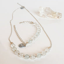 Load image into Gallery viewer, A set of light blue topaz silver jewelry including a necklace and a bracelet with silver accents, displayed on a white surface.