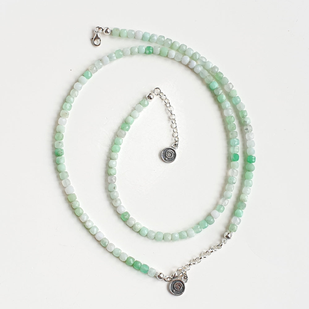 Set of green beaded necklace and bracelet on a white background