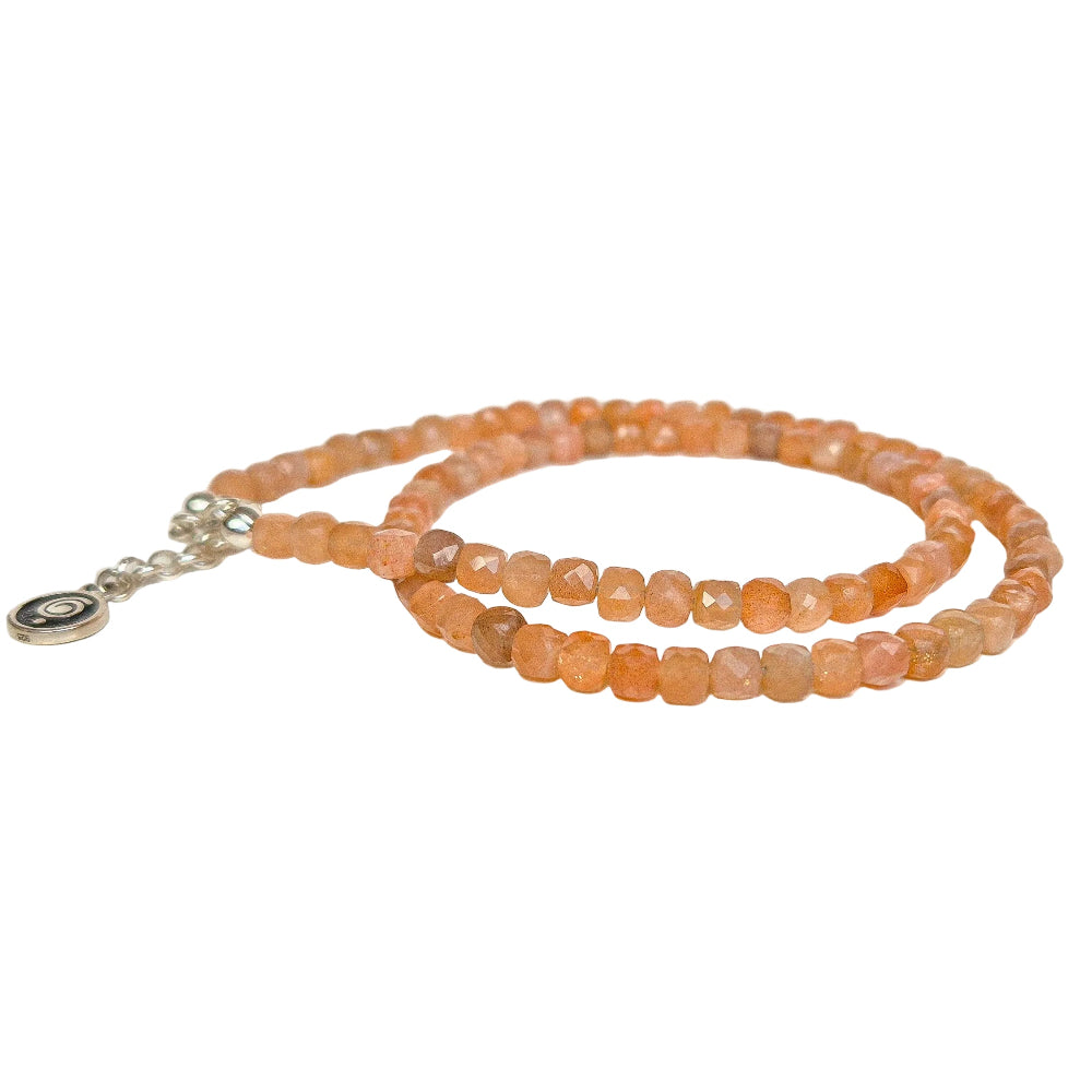 Necklace with peach-colored beads on a light beige background