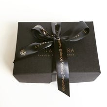 Load image into Gallery viewer, A black gift box with a ribbon bow, containing a silver pendant with pink quartz, packaged for presentation.