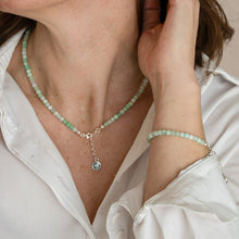 Load image into Gallery viewer, Person wearing a green beaded necklace and bracelet on a white shirt background