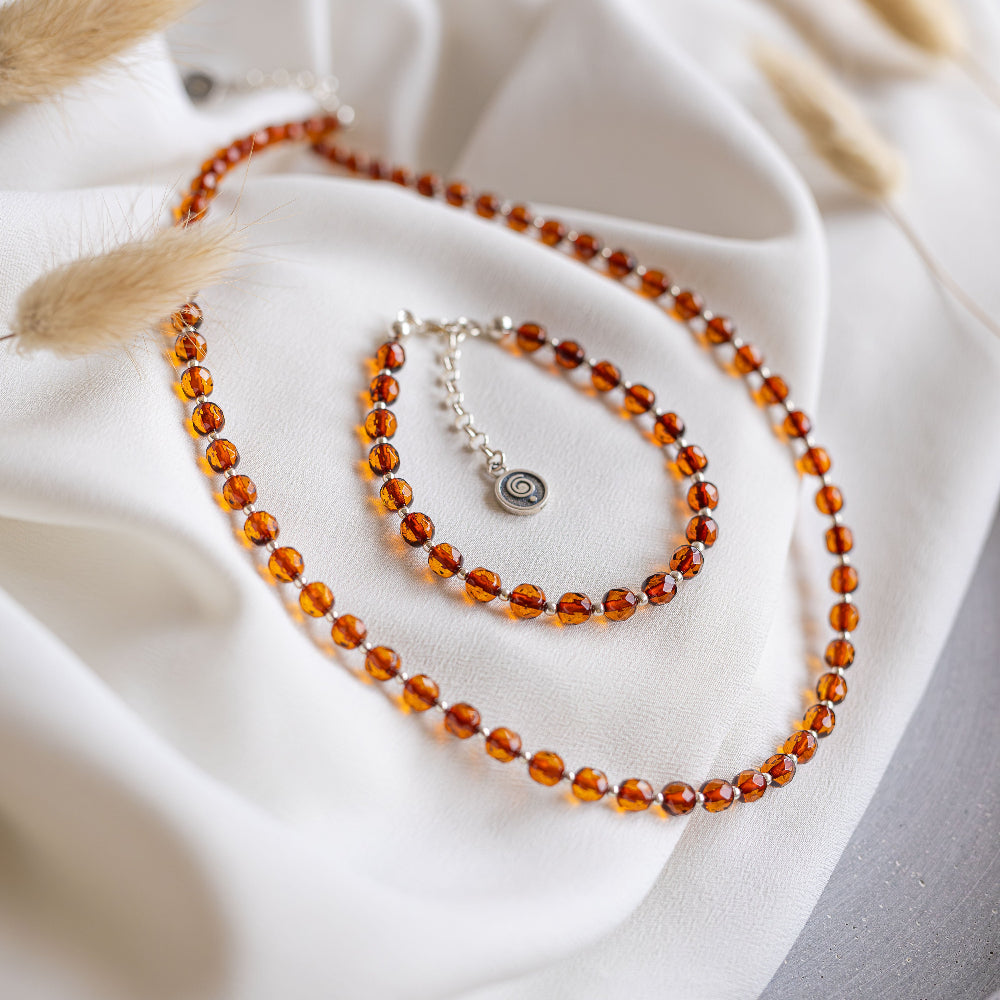 Beaded necklace and bracelet on a white fabric background