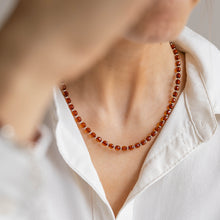 Load image into Gallery viewer, Person wearing a white shirt with a red amber beaded necklace