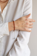 Load image into Gallery viewer, Person wearing a white shirt with a Baltica amber beaded bracelet on a neutral background