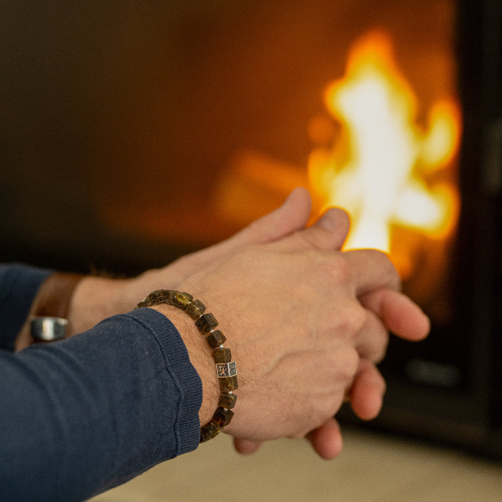 Men
 wearing a baltic amber bracelet with a warm fire in the background