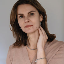 Load image into Gallery viewer, A woman wearing a silver necklace and bracelet with labradorite cube beads.