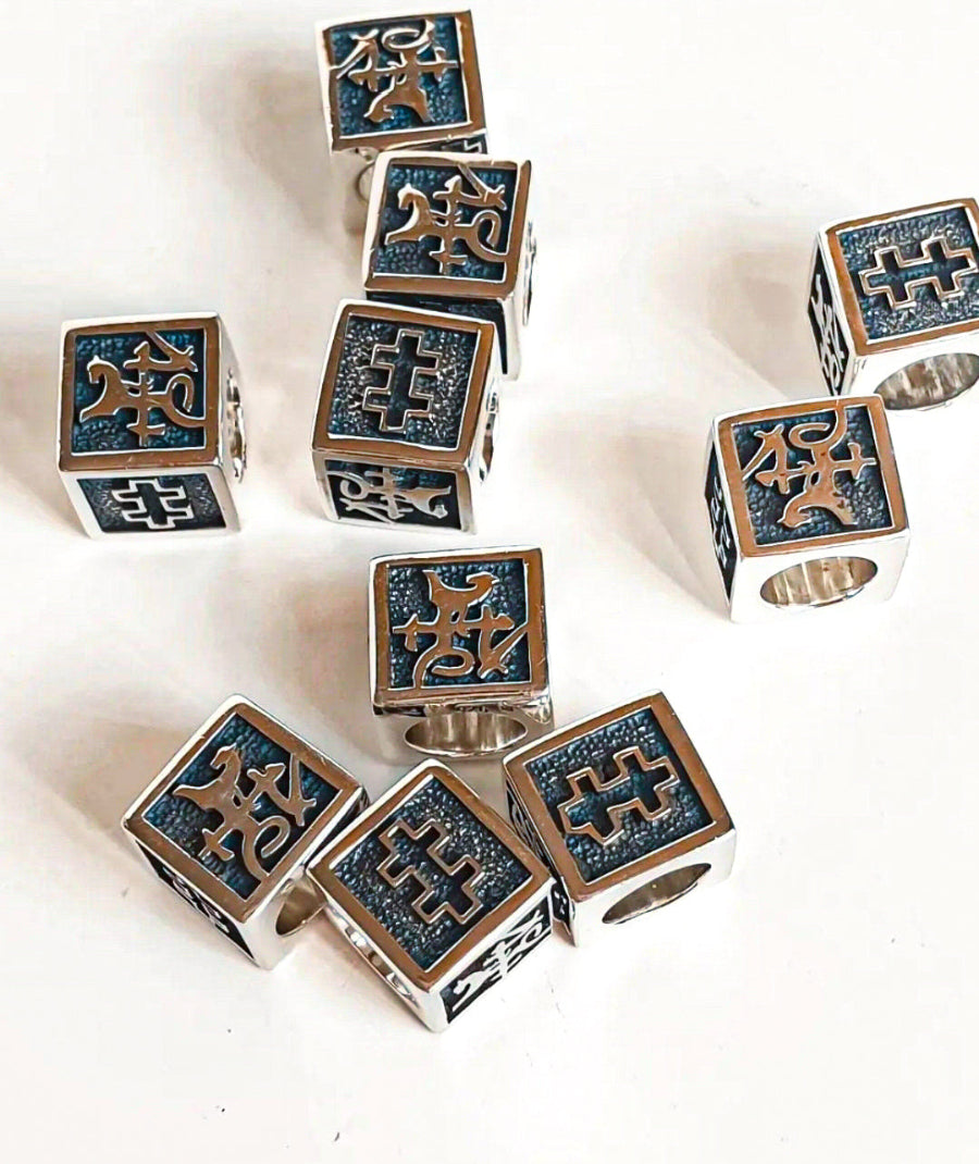 Set of silver and blue cube-shaped jewelry pieces on a white background