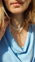 Load image into Gallery viewer, A beaded necklace with light blue aquamarine stones and a handmade silver medallion with a spiral design.